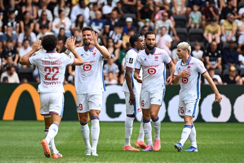 Lille's Portuguese defender #22 Tiago Santos (L) celebrates with teammates after scoring his team's first goal during the French L1 football match between Angers SCO and LOSC Lille at the Stade Raymond Kopa in Angers, western France on August 23, 2026. Sebastien Salom-Gomis / AFP