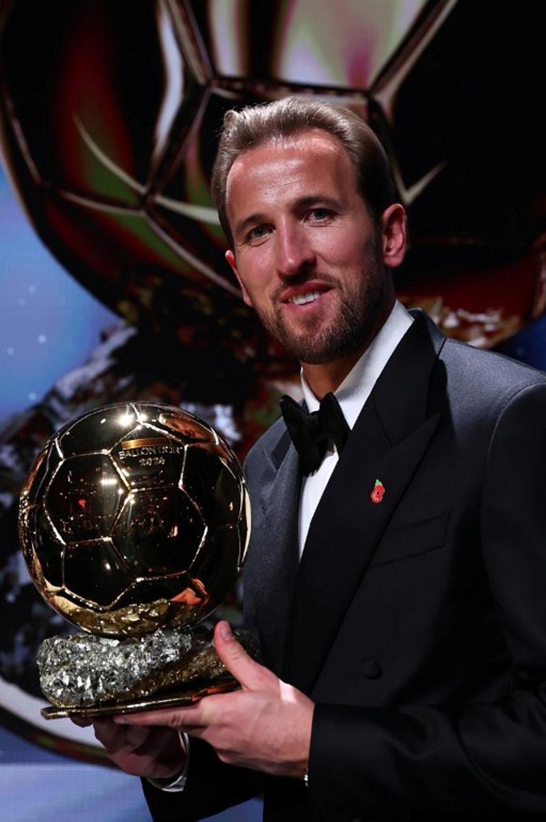 England and Bayern Munich forward Harry Kane poses with his trophy on stage after receiving the Ballon d'Or award for the best male footballer during the 2026 Ballon d'Or France Football award ceremony at the Palladium Theatre in London on October 26, 2026. Franck FIFE / AFP
