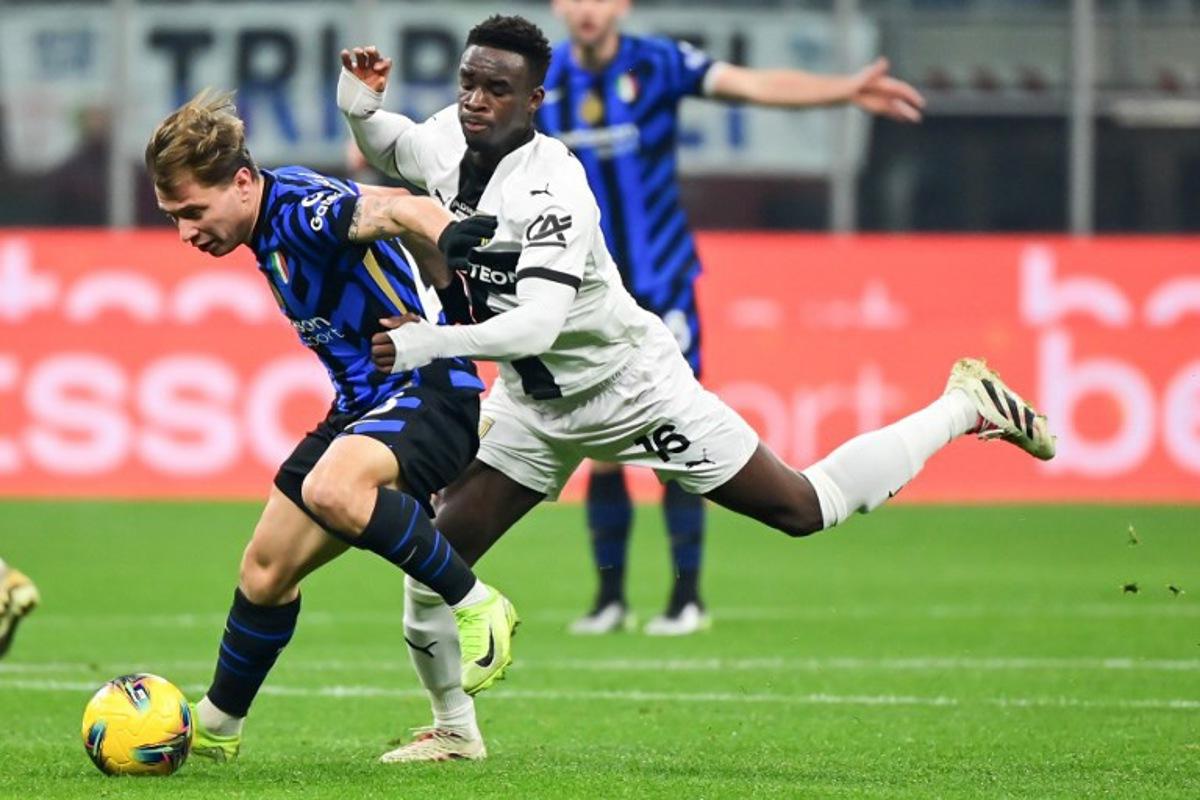 Inter Milan's Italian midfielder #23 Nicolo Barella (L) fights for the ball with Parma's Belgian midlfielder #16 Mandela Keita during the Italian Serie A football match between Inter Milan and Parma at the San Siro stadium in Milan, on December 6, 2024. Piero CRUCIATTI / AFP