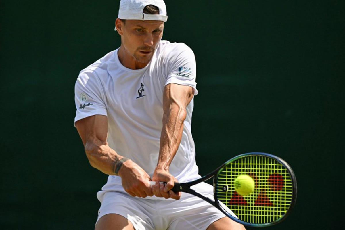Hungary's Marton Fucsovics plays a backhand return to France's Gael Monfils during their men's singles third round tennis match on the fifth day of the 2025 Wimbledon Championships at The All England Lawn Tennis and Croquet Club in Wimbledon, southwest London, on July 4, 2025. Glyn KIRK / AFP