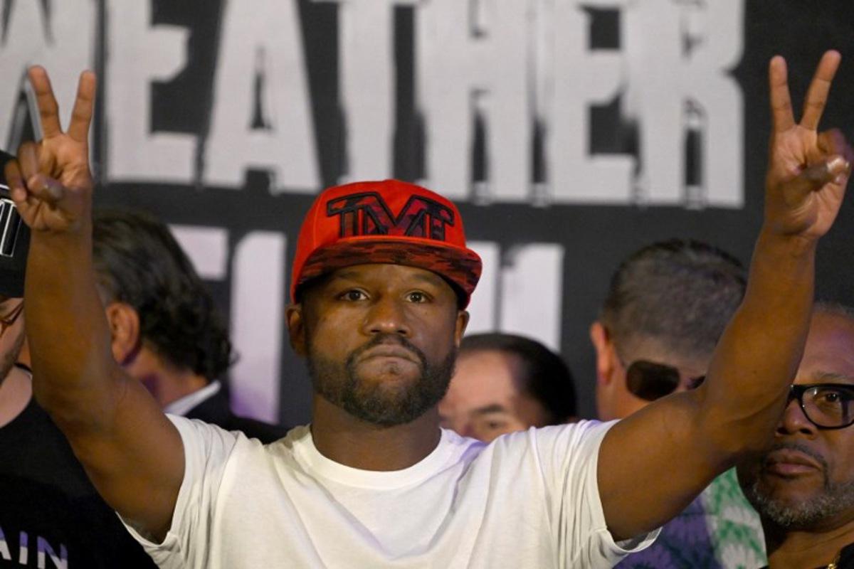 US boxer Floyd Mayweather Jr. gestures during the weighing ceremony for his upcoming exhibition fight against John Gutti III in Mexico City on August 23, 2024. Mayweather Jr. and Gotti III will face each other in an exhibition fight in Mexico on August 24, 2024. ALFREDO ESTRELLA / AFP