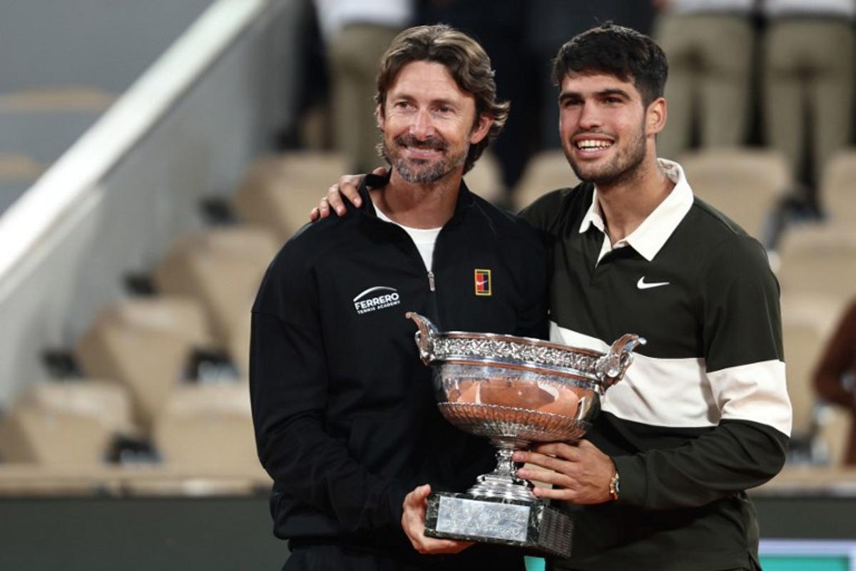Spain's Carlos Alcaraz poses with his Spanish coach Juan Carlos Ferrero (L) after winning against Italy's Jannik Sinner at the end of their men's singles final match on day 15 of the French Open tennis tournament on Court Philippe-Chatrier at the Roland-Garros Complex in Paris on June 8, 2025. Thibaud MORITZ / AFP