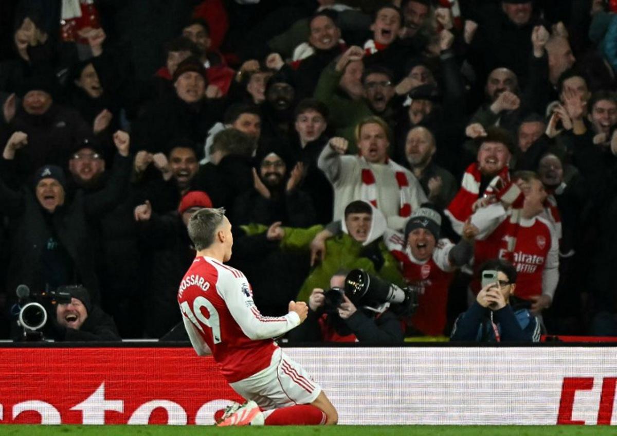 Arsenal's Belgian midfielder #19 Leandro Trossard celebrates scoring the opening goal during the English Premier League football match between Arsenal and Tottenham Hotspur at the Emirates Stadium in London on November 23, 2025. Ben STANSALL / AFP