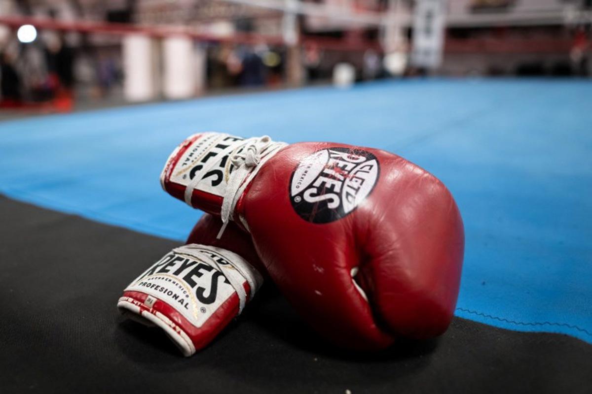 A pair of boxing gloves are seen at the sports and boxing hall at La Busserine neighbourhood in the northern Marseille on January 24, 2025. In Marseille, former boxers put their experience to the service of young people from the northern neighbourhoods, confronted with violence and drug trafficking, hoping to "save a few". Miguel MEDINA / AFP
