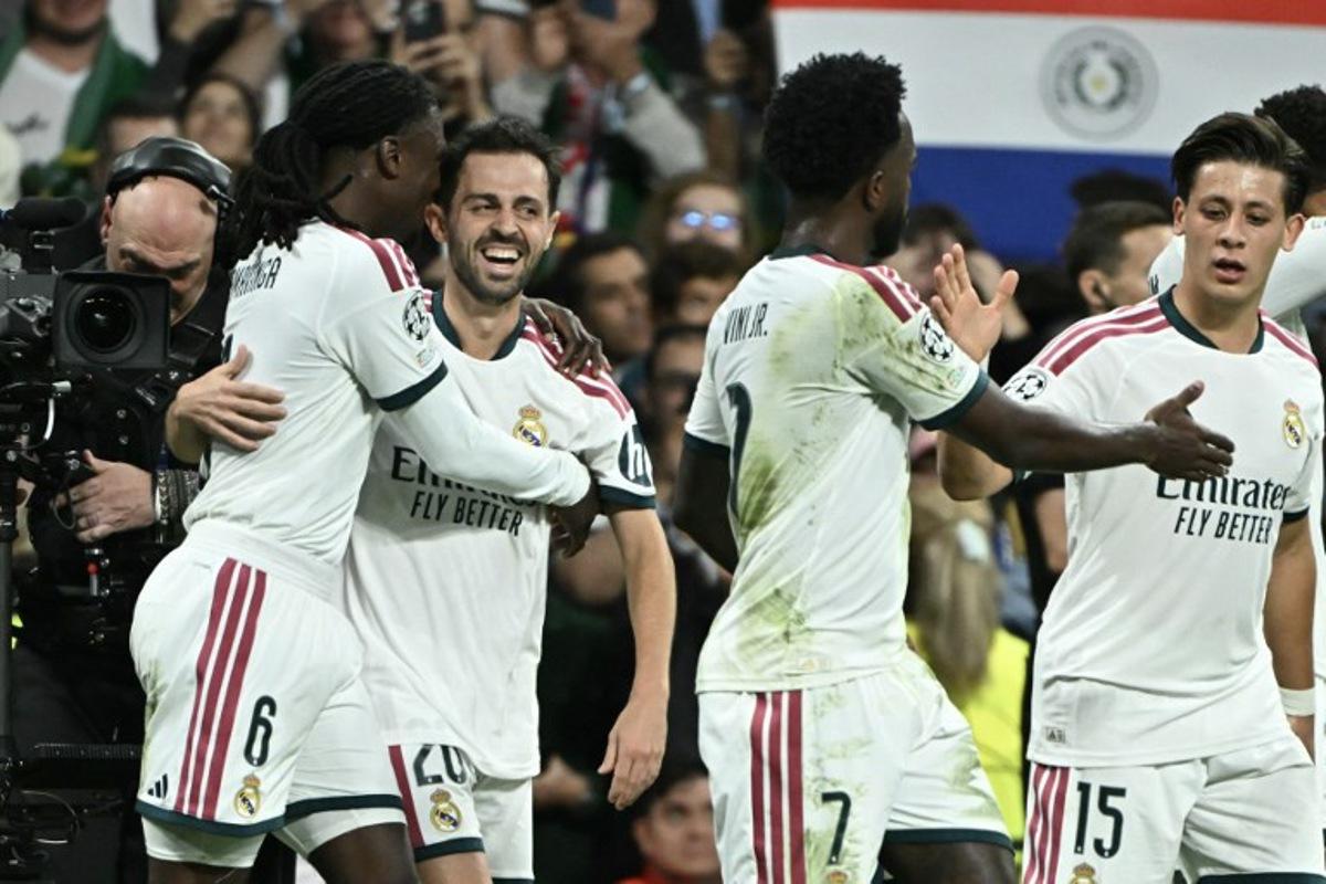 Real Madrid's Portuguese midfielder #20 Bernardo Silva (2L) celebrates scoring his team's first goal during their UEFA Champions League first round day 3 football match between Real Madrid CF and RB Leipzig at the Santiago Bernabeu stadium in Madrid on October 21, 2026. Javier SORIANO / AFP