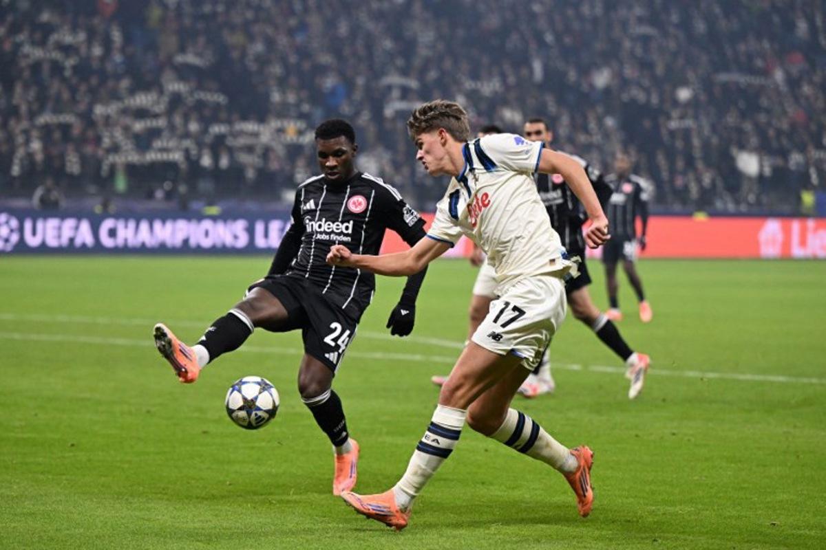 Frankfurt's Portuguese defender #24 Aurelio Buta (L) and Atalanta's Belgian forward #17 Charles De Ketelaere (R) vie for the ball during the UEFA Champions League league phase day 5 football match between Eintracht Frankfurt and Atalanta Bergamo in Frankfurt, Germany, on November 26, 2025. Kirill KUDRYAVTSEV / AFP