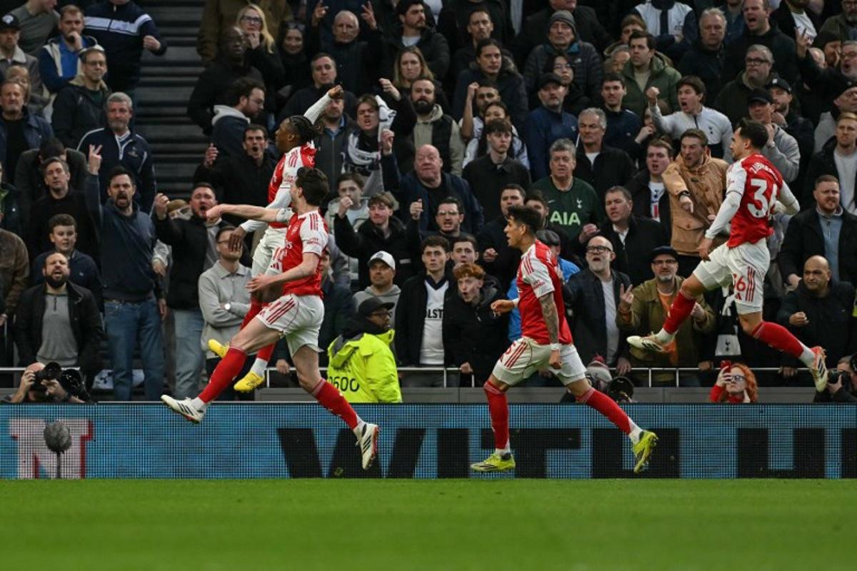 Arsenal's English midfielder #10 Eberechi Eze (far L) jumps with teammates as they celebrate after he scores the team's first goal during the English Premier League football match between Tottenham Hotspur and Arsenal at the Tottenham Hotspur Stadium in London, on February 22, 2026. Glyn KIRK / AFP