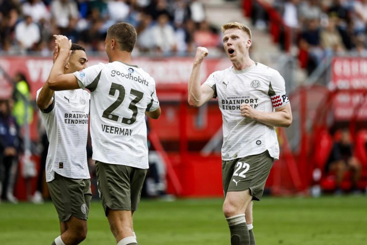 PSV Eindhoven's Dutch midfielder #22 Jerdy Schouten (R) celebrates his team's second goal during the Dutch Eredivisie football match between FC Twente and PSV Eindhoven at Philips Stadion in Eindhoven on August 17, 2025. Vincent Jannink / ANP / AFP