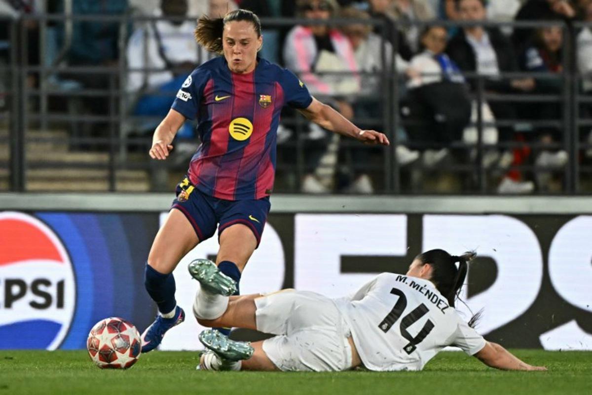 Real Madrid's Spanish defender #14 Maria Mendez and Barcelona's Spanish midfielder #16 Clara Serrajordi fight for the ball during the UEFA Women's Champions League quarter final first leg football match between Real Madrid CF and FC Barcelona at the Alfredo Di Stefano stadium in Madrid on March 25, 2026. Javier SORIANO / AFP