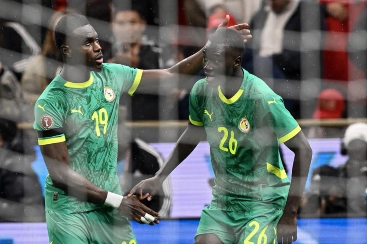 Senegal's defender #19 Moussa Niakhate congratulates Senegal's midfielder #26 Pape Gueye during the Africa Cup of Nations (CAN) final football match between Senegal and Morocco at the Prince Moulay Abdellah Stadium in Rabat on January 18, 2026. SEBASTIEN BOZON / AFP
