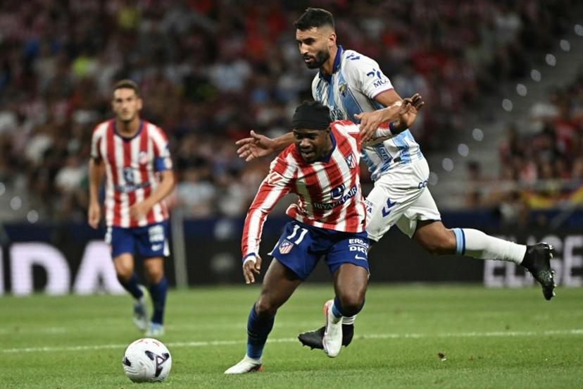Atletico Madrid's Nigerian forward #11 Ademola Lookman vies with Malaga's Spanish defender #04 Einar Galilea (R) during the Spanish league football match between Club Atletico de Madrid and Malaga CF at the Metropolitano Stadium in Madrid on August 19, 2026. Javier SORIANO / AFP