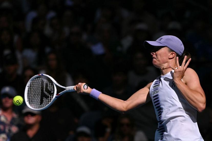 Poland's Iga Swiatek hits a return to Czech Republic's Marie Bouzkova during their women's singles match on day five of the Australian Open tennis tournament in Melbourne on January 22, 2026. WILLIAM WEST / AFP