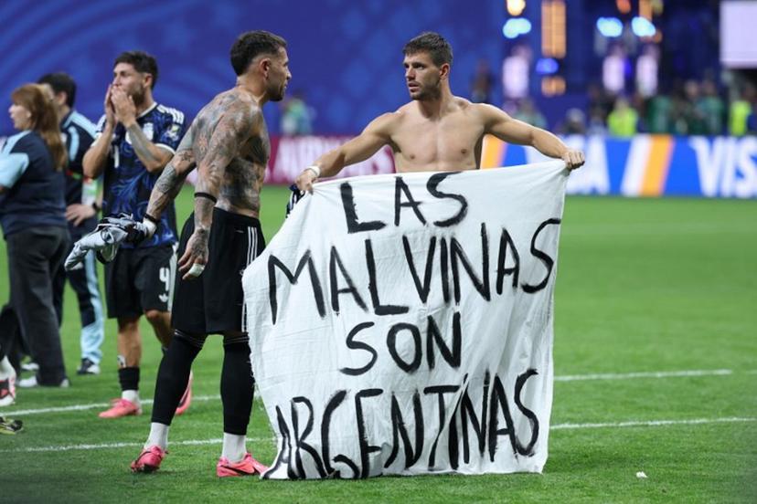 Argentina's defender #19 Nicolas Otamendi (L) and midfielder #11 Giovani Lo Celso show a banner that reads in Spanish, "The Malvinas (Falkland Islands) belong to Argentina," after winning the 2026 World Cup football tournament semi-final match between England and Argentina at the Atlanta Stadium in Atlanta on July 15, 2026. Thomas COEX / AFP