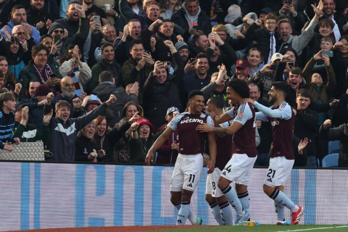 Aston Villa's English striker #11 Ollie Watkins (L) celebrates with teammates after scoring the openin goal during the English Premier League football match between Aston Villa and Newcastle United at Villa Park in Birmingham, central England on April 19, 2025. Darren Staples / AFP