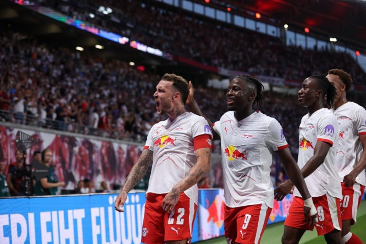 Leipzig's German defender #22 David Raum (L) celebrates his 3-1 during the German first division Bundesliga football match RB Leipzig v FC Cologne v in Leipzig, eastern Germany on September 20, 2025. Ronny HARTMANN / AFP
