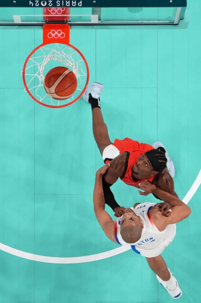 An overview shows France's #05 Nicolas Batum (Bottom) and Canada's #02 Shai Gilgeous-Alexander eye the ball in the men's quarterfinal basketball match between France and Canada during the Paris 2024 Olympic Games at the Bercy Arena in Paris on August 6, 2024. Evelyn HOCKSTEIN / POOL / AFP