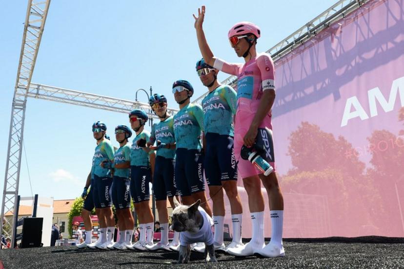 XDS Astana Team Uruguayan rider Guillermo Silva (R) wearing the overall leader's pink jersey (Maglia Rosa) holds his dog on a leash during the presentation prior the 4th stage of the Giro d'Italia 2026 - Tour of Italy cycling race between Catanzaro and Cosenza, Italy, on May 12, 2026. Luca Bettini / AFP