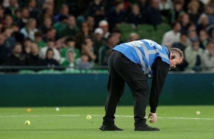 An official collects tennis thrown onto the pitch during the UEFA Nations League, League B - Group 3, football match between Republic of Ireland and Austria at the Aviva Stadium in Dublin, Ireland on October 1, 2026. Paul Faith / AFP
