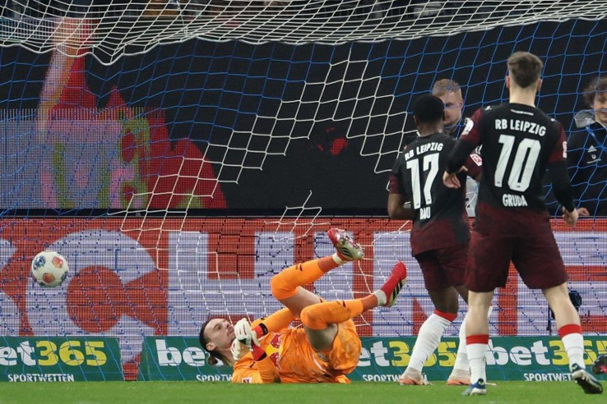 Leipzig's Belgian goalkeeper #26 Maarten Vandevoordt (L) fails to save the opening goal during the German first division Bundesliga football match between Hamburger SV and RB Leipzig in Hamburg, northern Germany on March 1, 2026. IBRAHIM OT / AFP