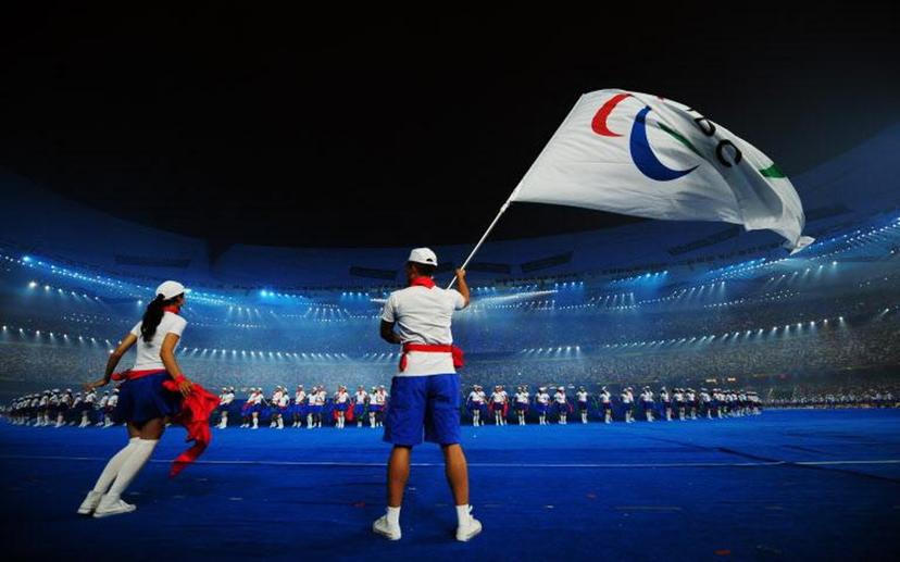A performer waves the International Paralympic Committee (IPC) flag as the 2008 Beijing Paralympic Games opening ceremony kicks off at the National Stadium, better known as the Bird's Nest, in Beijing on September 6, 2008. More than 4,000 athletes were at the opening of what promises to be a dazzling Paralympics, with the head of the international movement predicting a fantastic Games. AFP PHOTO/FREDERIC J. BROWN Frederic J. BROWN / AFP