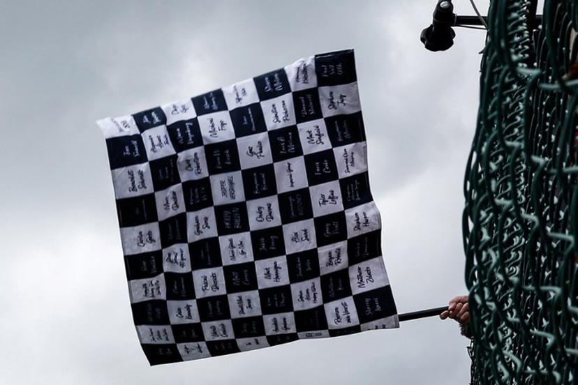 A race marshal waves the checkered flag at the end of the Formula One Belgian Grand Prix at the Spa-Francorchamps Circuit in Spa on July 30, 2023. SIMON WOHLFAHRT / POOL / AFP