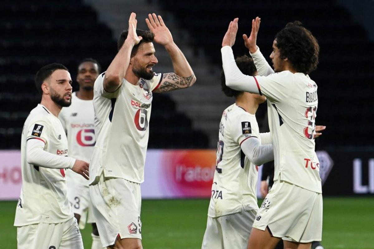 Lille's French forward #09 Olivier Giroud (C) celebrates with teammates after scoring his team's first goal from the penalty spot during the French L1 football match between SCO Angers and Lille LOSC at the Raymond-Kopa Stadium in Angers, western France, on February 22, 2026. JEAN-FRANCOIS MONIER / AFP