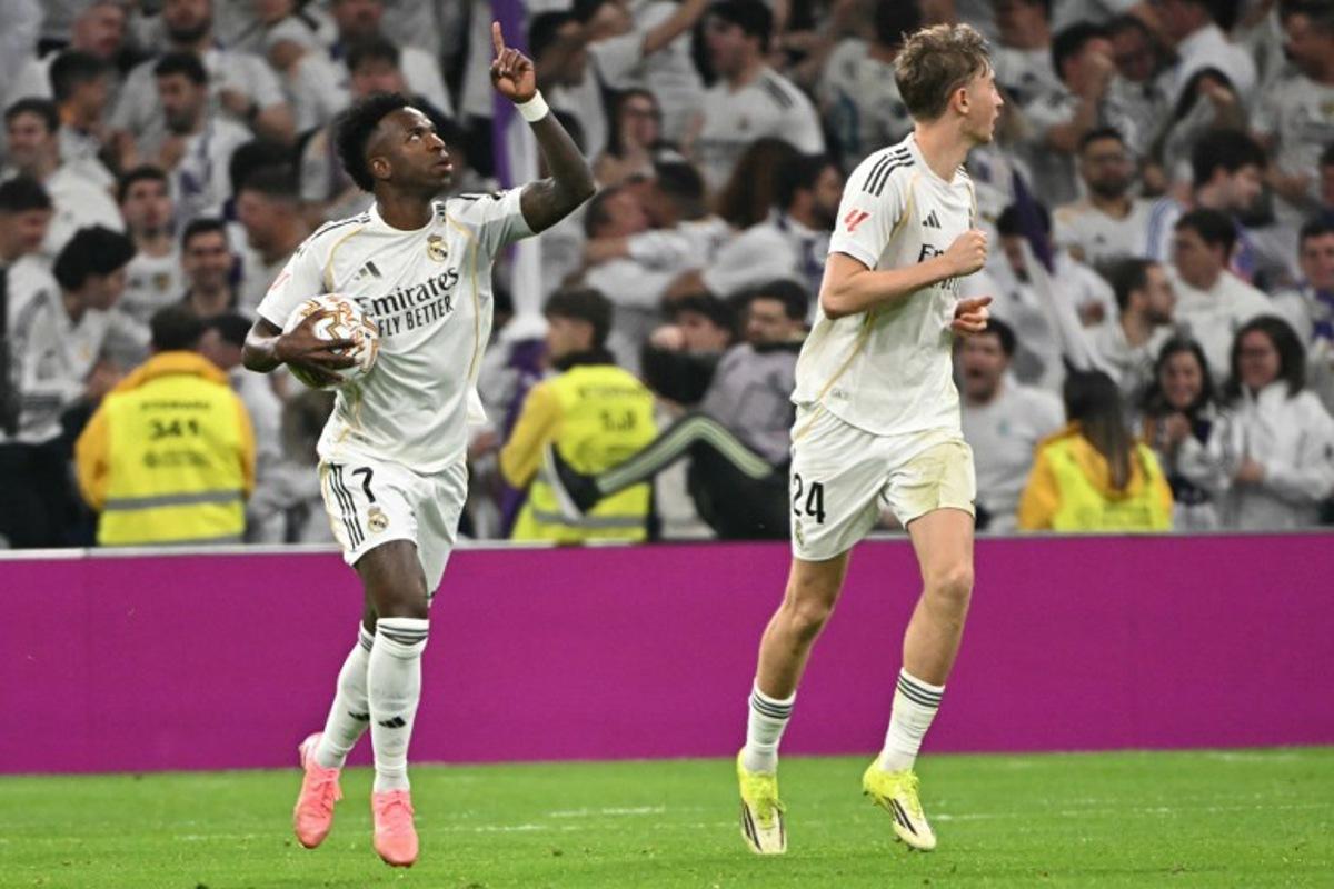 Real Madrid's Brazilian forward #07 Vinicius Junior (L) celebrates scoring his team's first goal during the Spanish league football match between Real Madrid CF and Club Atletico de Madrid at Santiago Bernabeu Stadium in Madrid on March 22, 2026. Javier SORIANO / AFP