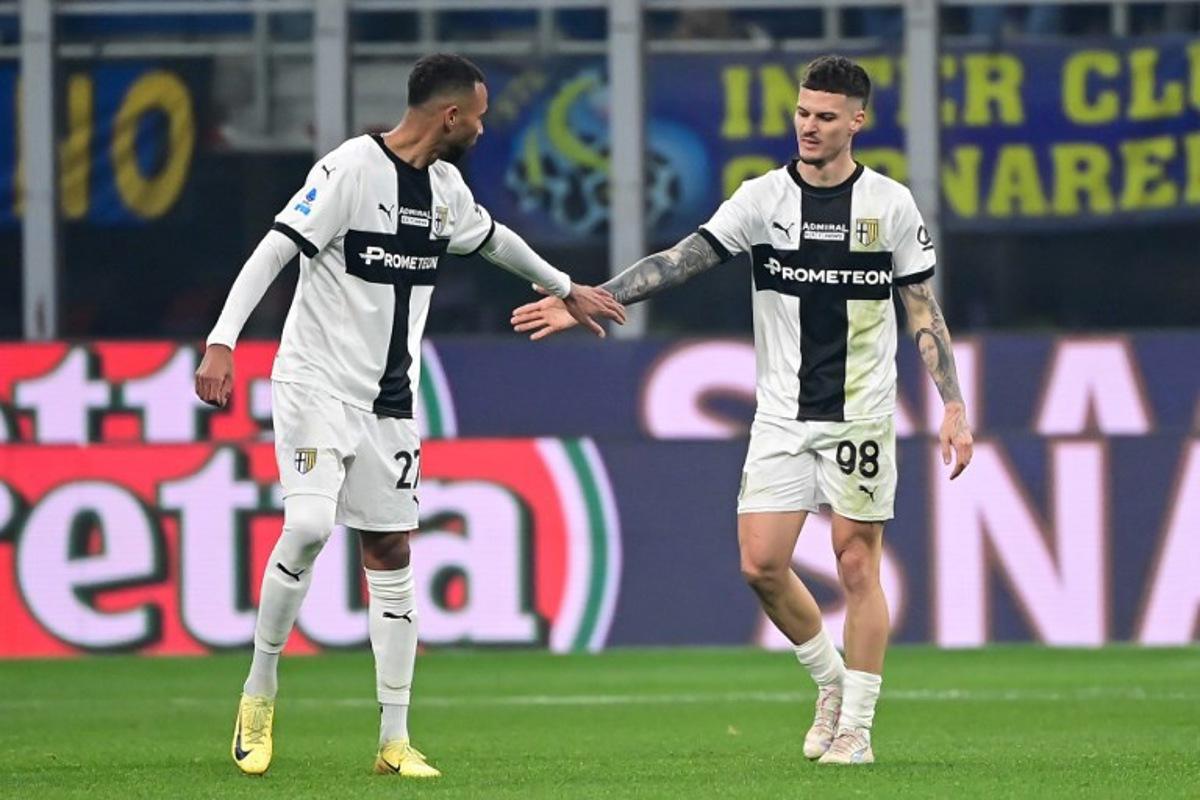 Parma's Romanian forward #98 Dennis Man (R) celebrates with Parma's Brasilian midfielder #27 Hernani (L) after an own goal by Inter Milan's Italian defender #36 Matteo Darmian (not pictured) during the Italian Serie A football match between Inter Milan and Parma at the San Siro stadium in Milan, on December 6, 2024. Piero CRUCIATTI / AFP