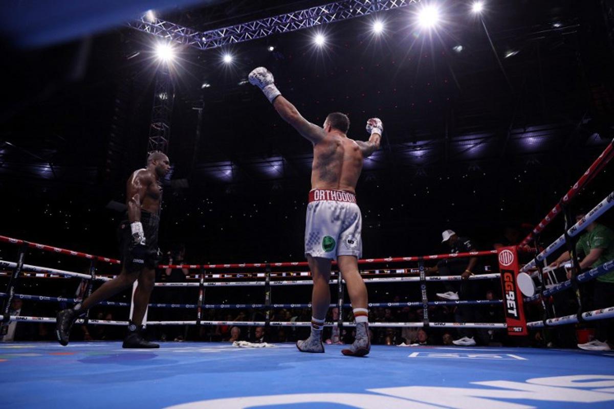 Ukraine's Oleksandr Usyk (R) celebrates defeating Britain's Daniel Dubois in their undisputed world heavyweight boxing title bout at Wembley Stadium in London on July 19, 2025. Adrian Dennis / AFP