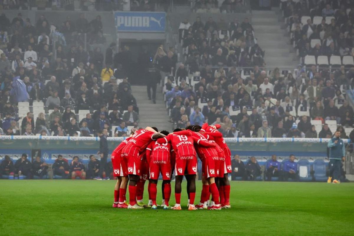 Montpellier's players gather in a huddle ahead of the French L1 football match between Olympique de Marseille (OM) and Montpellier HSC at Stade Velodrome in Marseille, southern France on April 19, 2025. CLEMENT MAHOUDEAU / AFP