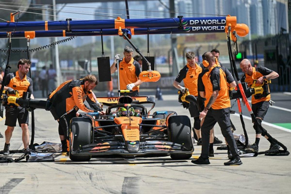 Mechanics work on the car of McLaren's British driver Lando Norris in the pits during the first practice session of the Formula One Chinese Grand Prix at the Shanghai International Circuit in Shanghai on March 21, 2025. HECTOR RETAMAL / AFP