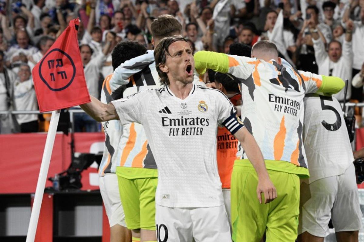 Real Madrid's Croatian midfielder #10 Luka Modric and teammates celebrate their second goal scored by Real Madrid's French midfielder #14 Aurelien Tchouameni during their Spanish Cup, Copa del Rey (King's Cup) final football match between FC Barcelona and Real Madrid CF at La Cartuja stadium in Seville on April 26, 2025. Josep LAGO / AFP