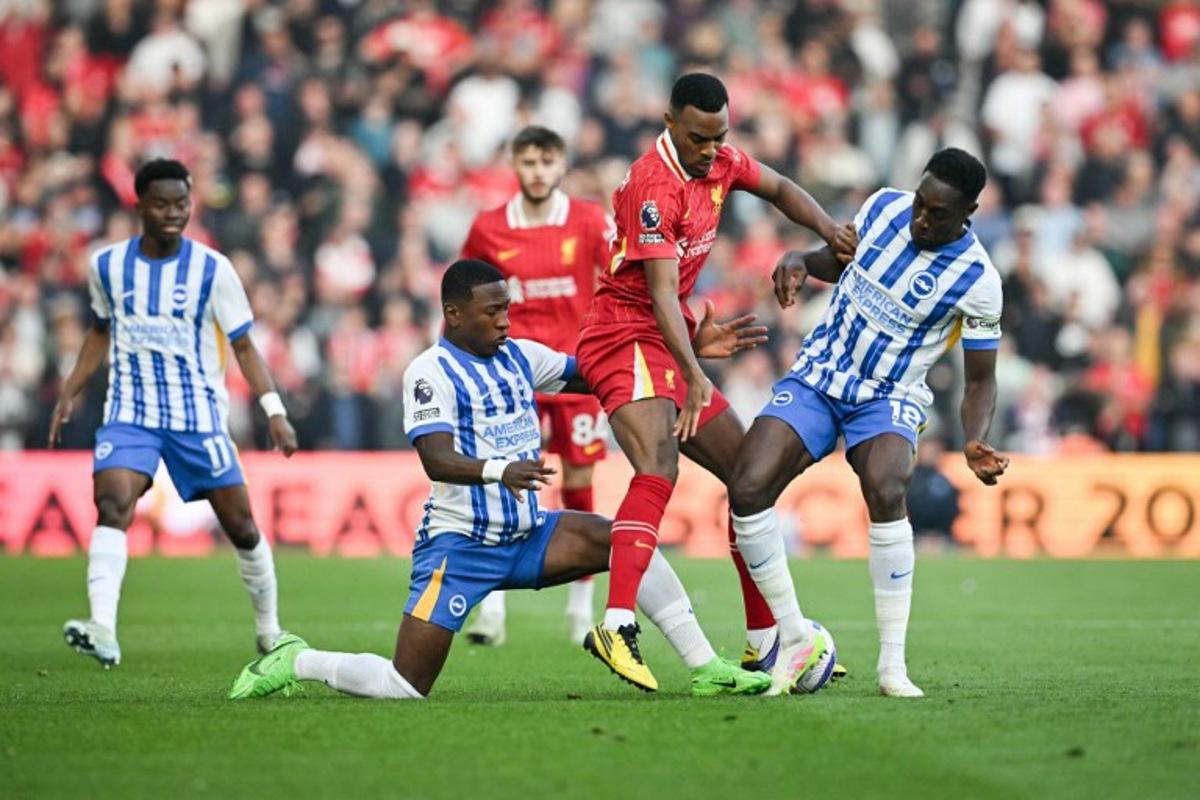 Liverpool's Dutch midfielder #38 Ryan Gravenberch (C) fights for the ball with Brighton's Ecuadorian defender #30 Pervis Estupinan (L) and Brighton's English striker #18 Danny Welbeck (R) during the English Premier League football match between Brighton and Hove Albion and Liverpool at the American Express Community Stadium in Brighton, southern England on May 19, 2025. Glyn KIRK / AFP