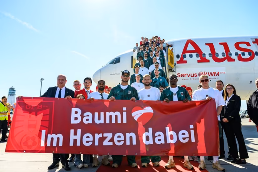Members of Austria's national football team hold a banner reading "Baumi - with us in our hearts", addressing injured team player Christoph Baumgartner nicknamed "Baumi" who will miss the World Cup due to injury, as the team boards a plane before departing from the Schwechat airport near Vienna, Austria, on June 4, 2026, ahead of the FIFA 2026 World Cup. MAX SLOVENCIK / APA / AFP
