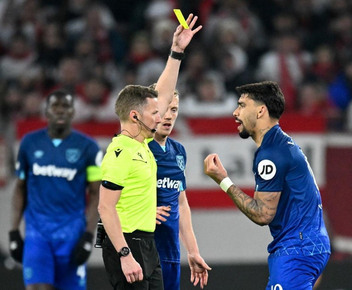 West Ham United's Brazilian midfielder #10 Lucas Paqueta (R) is shown a yellow card by Spanish referee Alejandro Hernandez during the UEFA Europa League round of 16 first leg football match between SC Freiburg and West Ham United FC in Freiburg, southwestern Germany on March 7, 2024. THOMAS KIENZLE / AFP