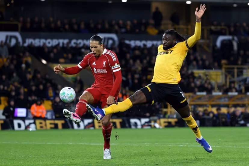 Liverpool's Dutch defender #04 Virgil van Dijk battles for possession with Wolverhampton Wanderers' Nigerian striker #14 Tolu Arokodare during the English Premier League football match between Wolverhampton Wanderers and Liverpool at the Molineux stadium in Wolverhampton, central England on March 3, 2026. Darren Staples / AFP
