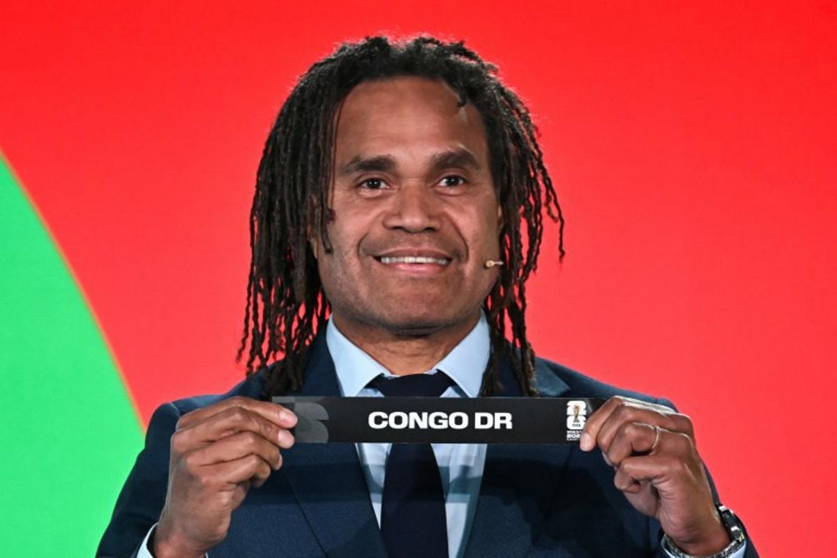 French former player Christian Karembeu shows the paper slip of DR Congo during the 2026 FIFA World Cup Play-Off Tournament draw at the FIFA's Home of Football in Zurich on November 20, 2025. Fabrice COFFRINI / AFP