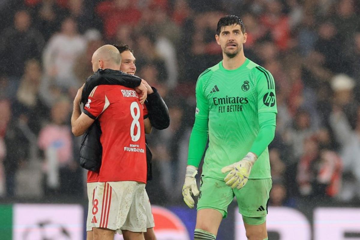 Real Madrid's Belgian goalkeeper #01 Thibaut Courtois (R) reacts past Benfica's Norwegian midfielder #08 Fredrik Aursnes and Ukrainian midfielder #10 Georgiy Sudakov after the UEFA Champions League league phase day 8 football match between SL Benfica and Real Madrid CF at Estadio da Luz in Lisbon on January 28, 2026. PATRICIA DE MELO MOREIRA / AFP