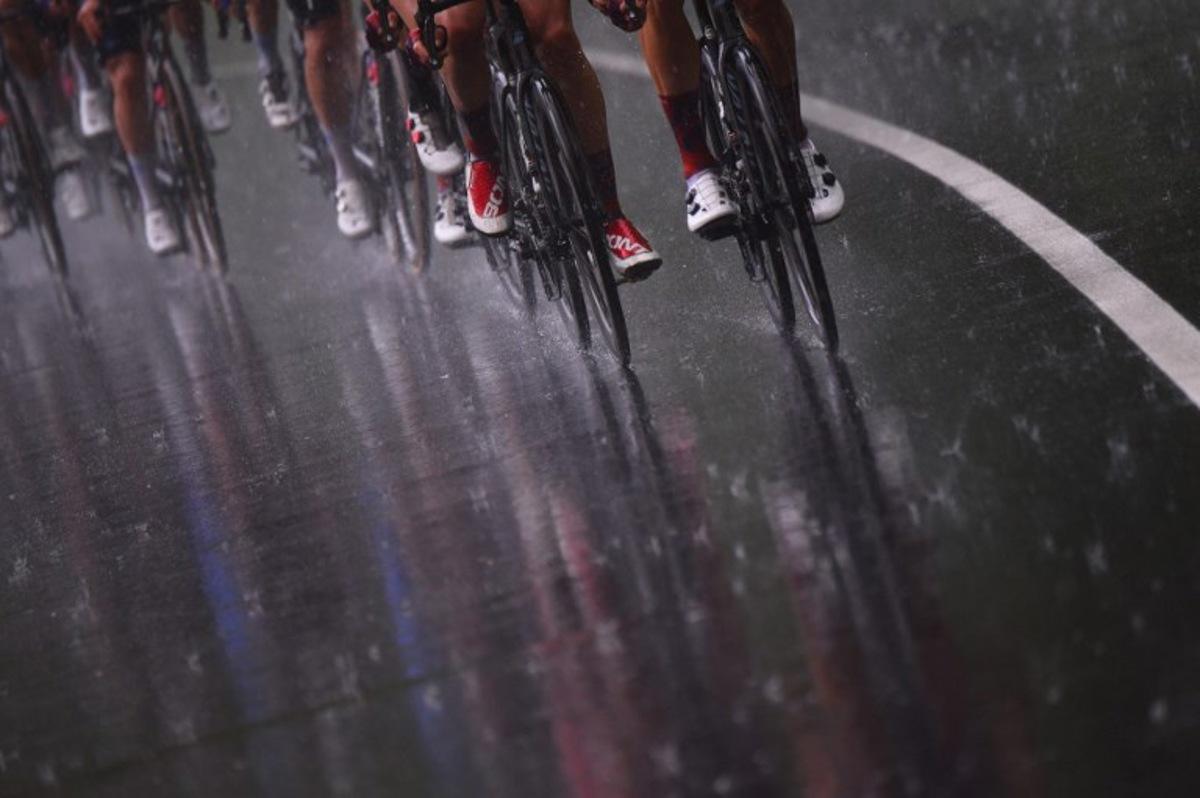 The pack rides under the rain during the sixth stage of the Giro d'Italia 2021 cycling race, 160 km between Grotte di Frasassi and Ascoli Piceno (San Giacomo) on May 13, 2021. Dario BELINGHERI / AFP