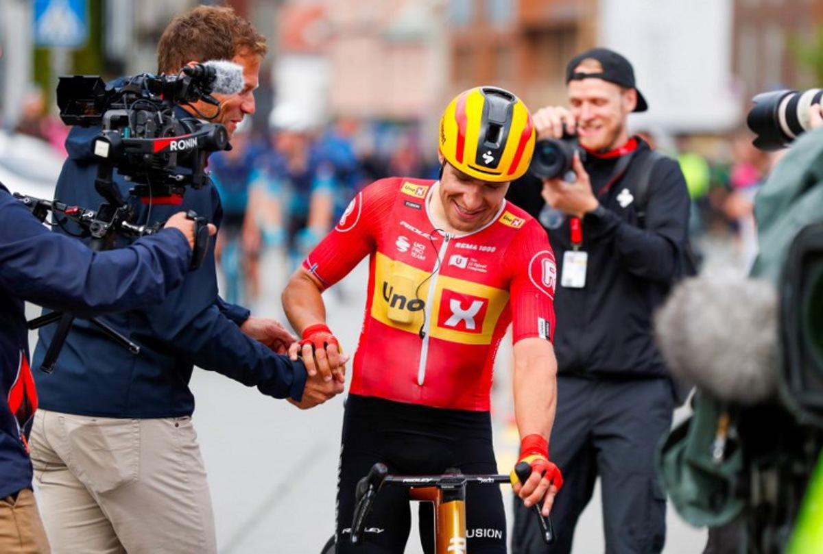 Uno-X Pro Cycling Team's Norwegian rider Fredrik Dversnes (C) is welcomed by Uno-X Mobility's CEO Thor Hushovd (L) after winning the fourth and final stage of the Arctic Cyling Race 2025 in Tromso, Norway, on August 10, 2025. Rune Stoltz Bertinussen / NTB / AFP