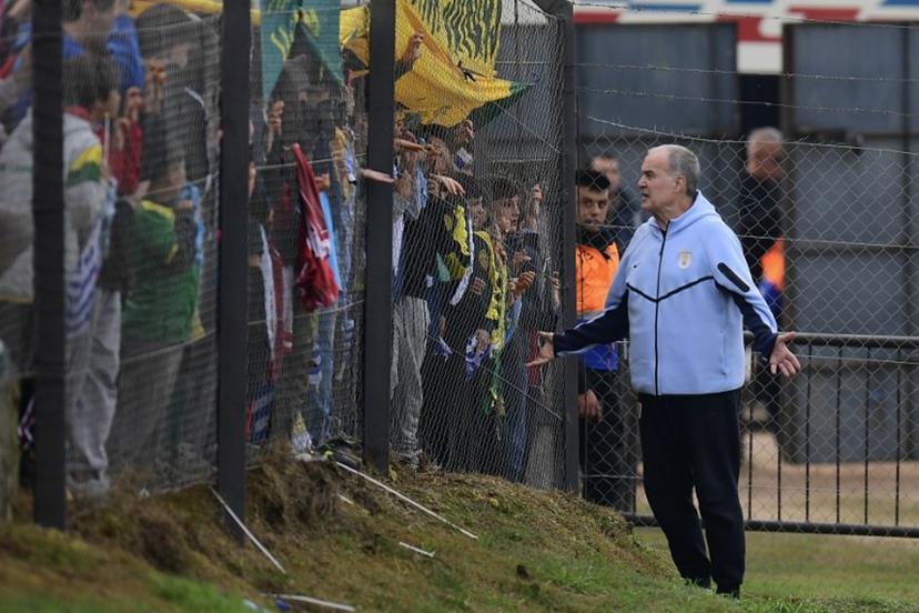 Uruguay's fnational football team coach, Argentinian Marcelo Bielsa, greets fans during a farewell activity with children ahead of the departure of the squad for the FIFA World Cup 2026, at the Tito Lopez Lopez stadium in Pando, Canelones department, Uruguay on June 5, 2026. Dante FERNANDEZ / AFP