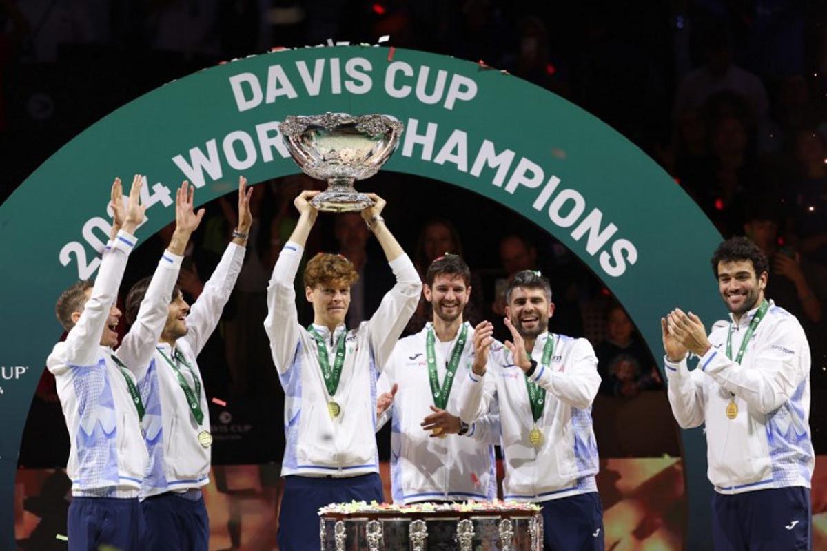 Italy's Jannik Sinner raises the trophy with teammates after winning the Davis Cup Finals at the Palacio de Deportes Jose Maria Martin Carpena arena in Malaga, southern Spain, on November 24, 2024. Thomas COEX / AFP