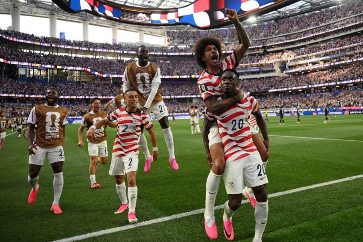 US forward #20 Folarin Balogun celebrates with teammates after scoring his team's third goal during the 2026 World Cup Group D football match between USA and Paraguay at the Los Angeles Stadium in Inglewood on June 12, 2026. Patrick T. Fallon / AFP