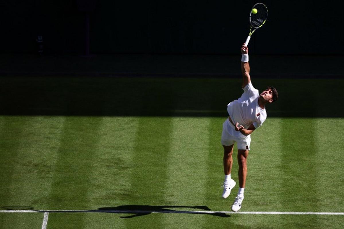 Spain's Carlos Alcaraz serves to Italy's Fabio Fognini during their men's singles first round tennis match on the first day of the 2025 Wimbledon Championships at The All England Lawn Tennis and Croquet Club in Wimbledon, southwest London, on June 30, 2025. HENRY NICHOLLS / AFP