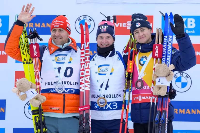 (From left) Second place Germany's Philipp Nawrath, winner Norway's Johan-Olav Botn and third place France's Eric Perrot celebrate on the podium after the men's 15km mass start event of the IBU Biathlon World Cup in Holmenkollen, Oslo on March 22, 2026. Heiko Junge / NTB / AFP