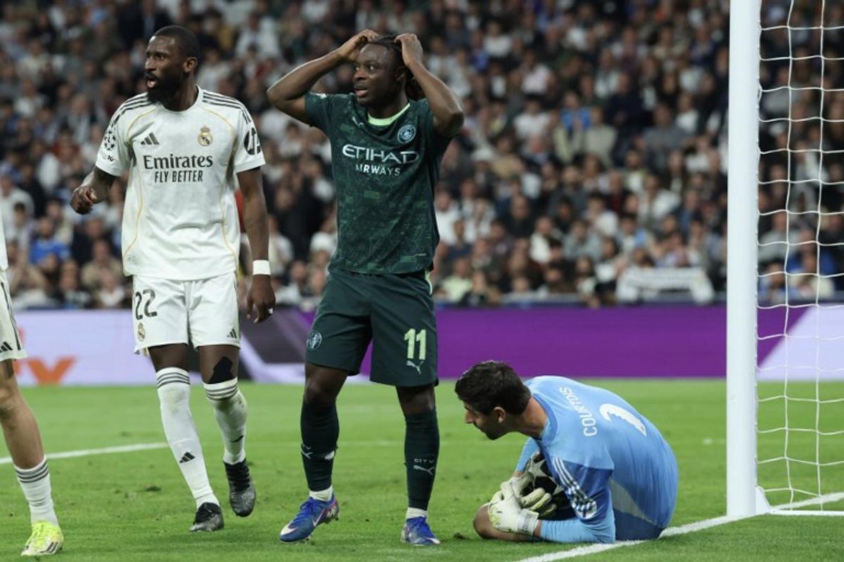 Manchester City's Belgian midfielder #11 Jeremy Doku (C) reacts after missing a chance to score during the UEFA Champions League last 16 first leg football match between Real Madrid CF and Manchester City at Santiago Bernabeu Stadium in Madrid on March 11, 2026. Pierre-Philippe MARCOU / AFP