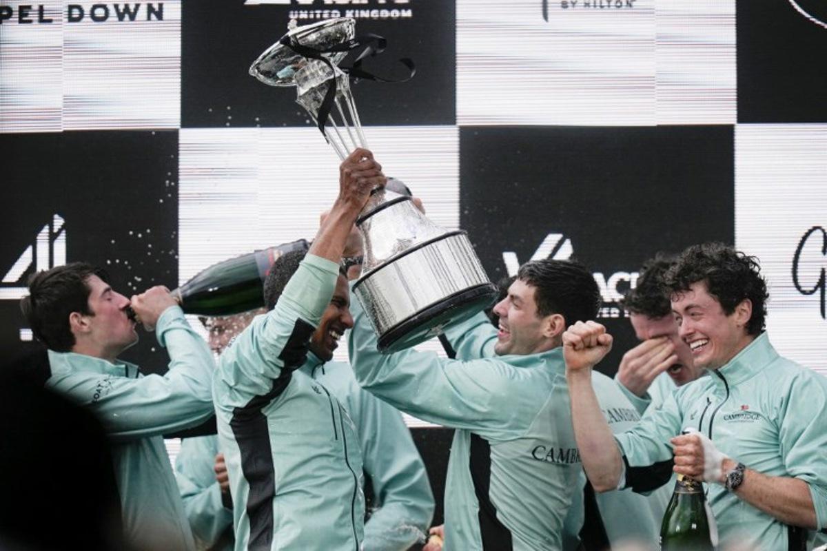 Cambridge's French president, Noam Mouelle celebrates lifts the trophy after winning the 171th men's boat race between Oxford University and Cambridge University on the River Thames in London on April 4, 2026. CARLOS JASSO / AFP