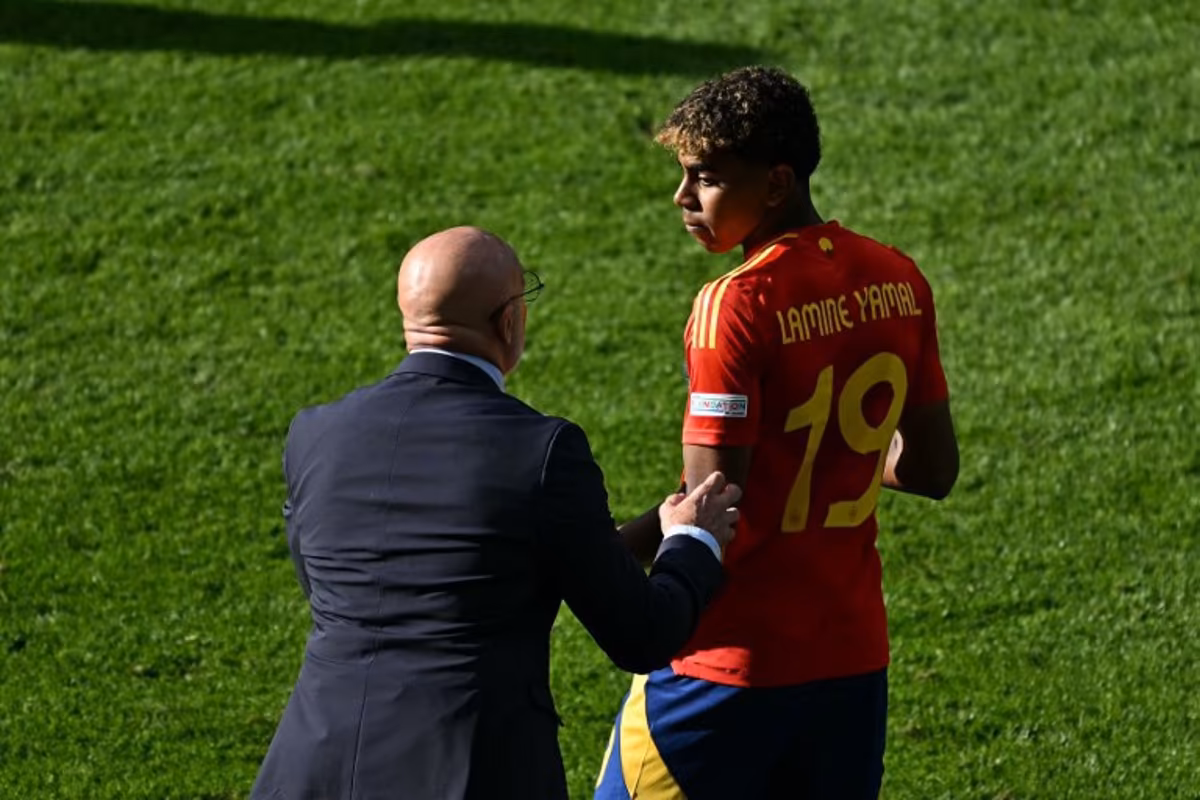 Spain's head coach Luis de la Fuente speaks with Spain's forward #19 Lamine Yamal during the UEFA Euro 2024 Group B football match between Spain and Croatia at the Olympiastadion in Berlin on June 15, 2024. GABRIEL BOUYS / AFP