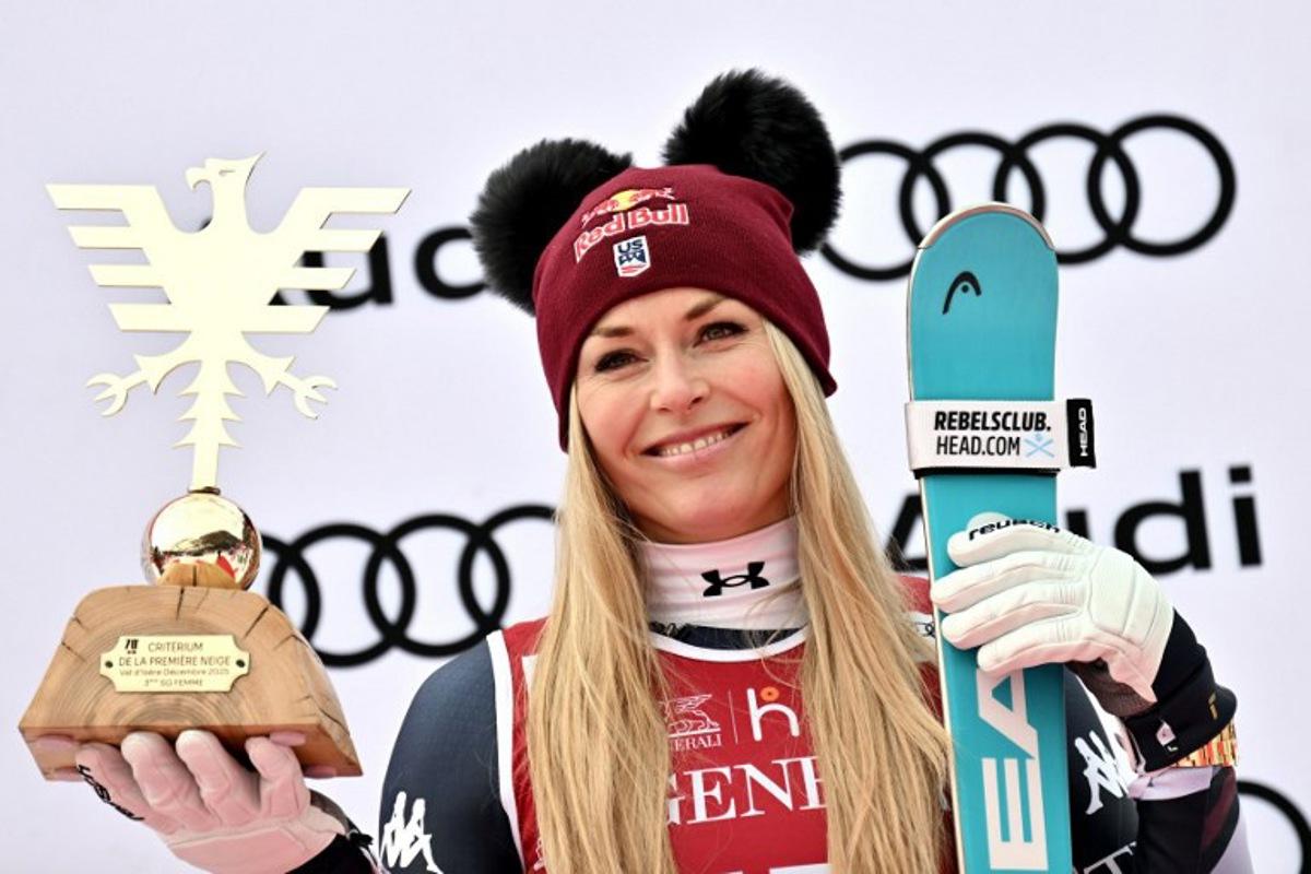 Third-placed US Lindsey Vonn holds her trophy as she celebrates on the podium of the women's Super G event during the FIS Alpine Ski World Cup 2025-2026, in Val d'Isere, southwestern France, on December 21, 2025. Jeff PACHOUD / AFP