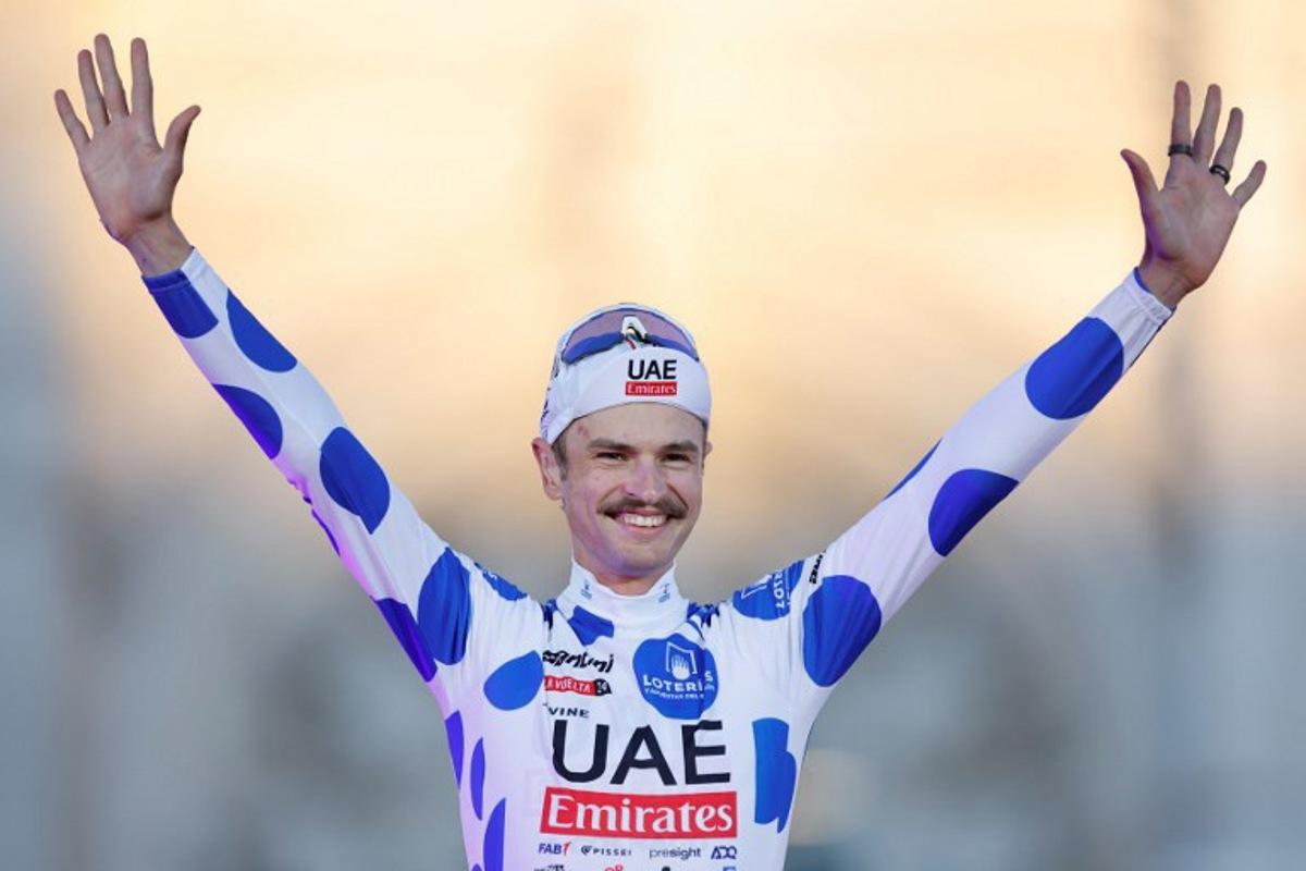 Team UAE's Jay Vine celebrates on the podium wearing the best climber jersey after the last stage of the Vuelta a Espana, a 24,6 km time-trial race between Madrid and Madrid, on September 8, 2024. OSCAR DEL POZO / AFP